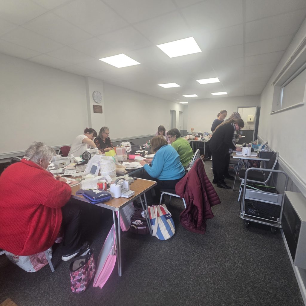 Cardmaking technique class participants creating pop up flower cards with stamped images and coordinating dies.