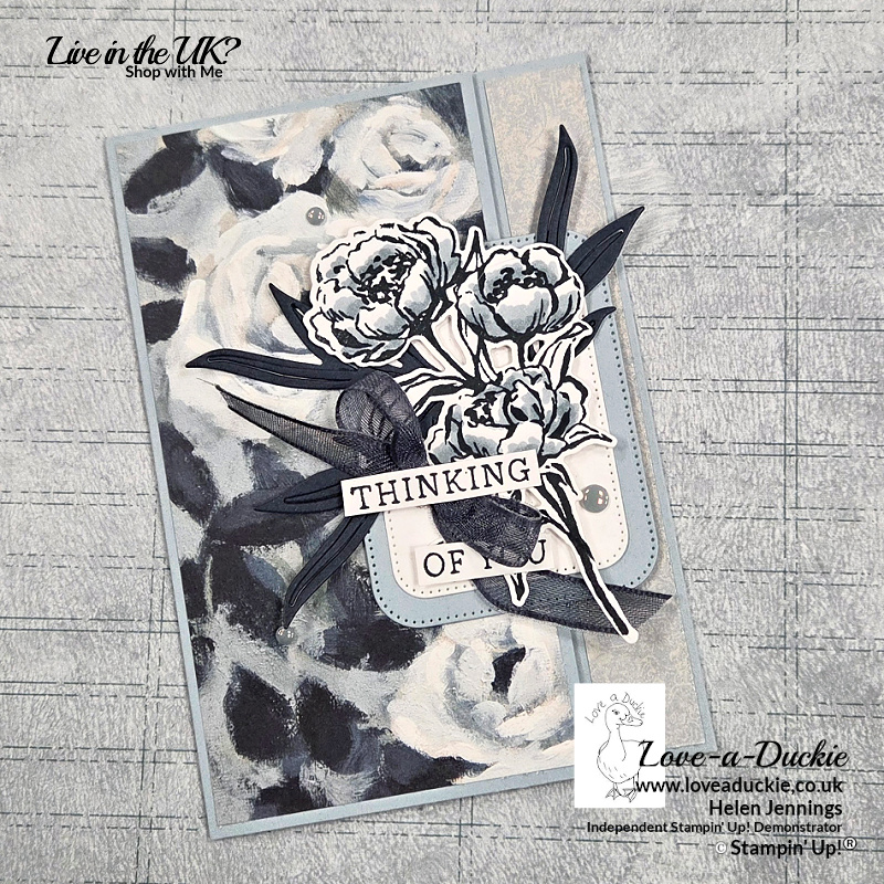 Handmade fold back fun fold card featuring blue and grey floral designer paper, layered stamped flowers from the Gallery Blooms bundle, Secret Sea ribbon and Cloud Cover flat pearls on a soft blue card base