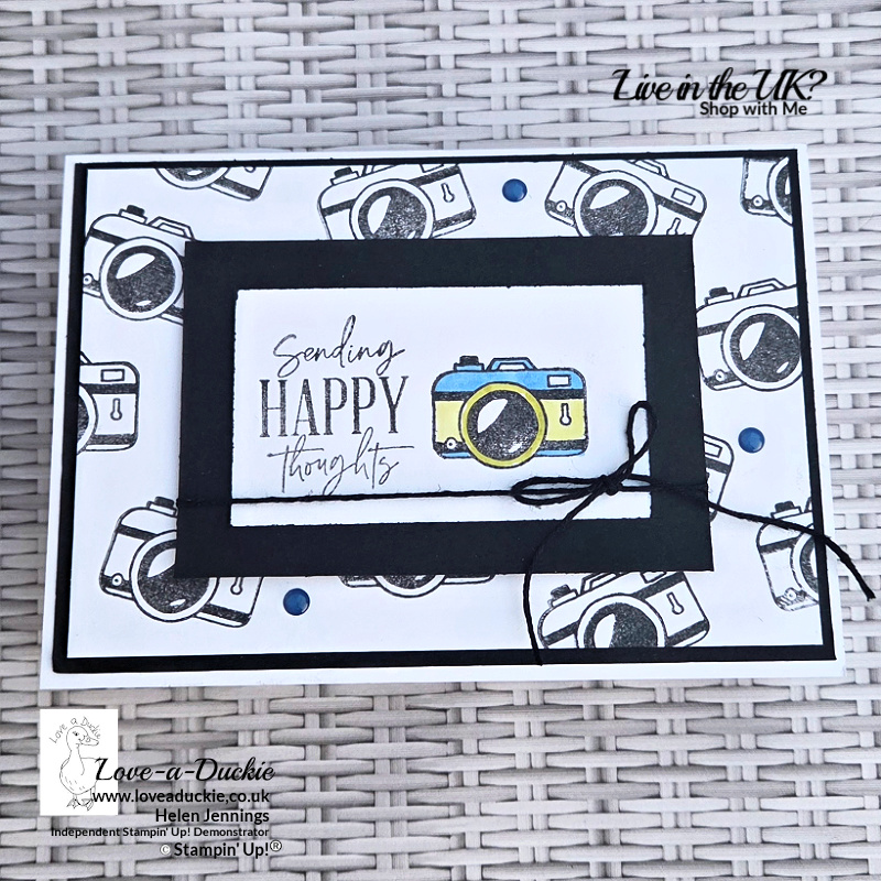 Handmade black-and-white camera card with a repeated stamped background, black frame, coloured camera and Sending Happy Thoughts sentiment.